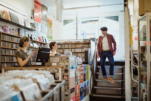 Image of man in local vinyl record store, a trend that is back in fashion