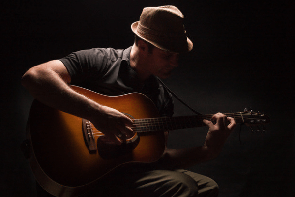 Photo of a man playing the guitar