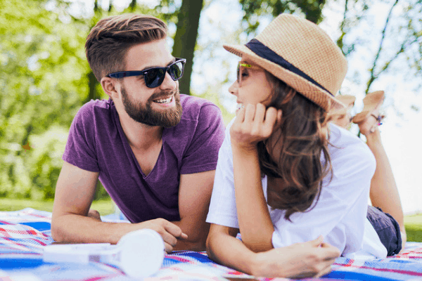 Photo of young couple on a picnic blanket