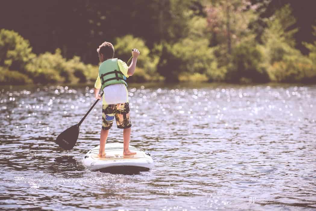 boy on a stand up paddle board