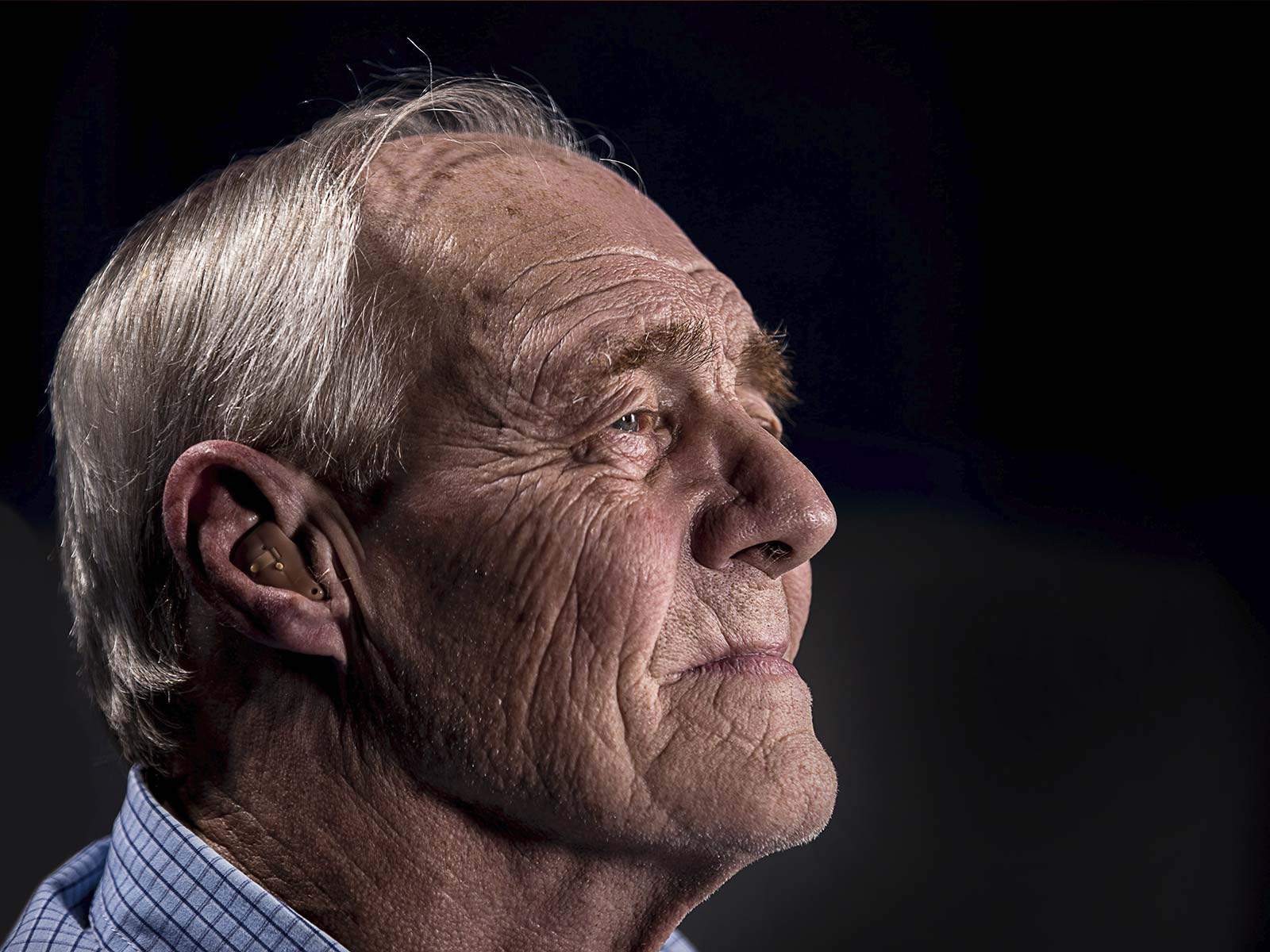 A photo of a gentleman wearing a hearing aid.