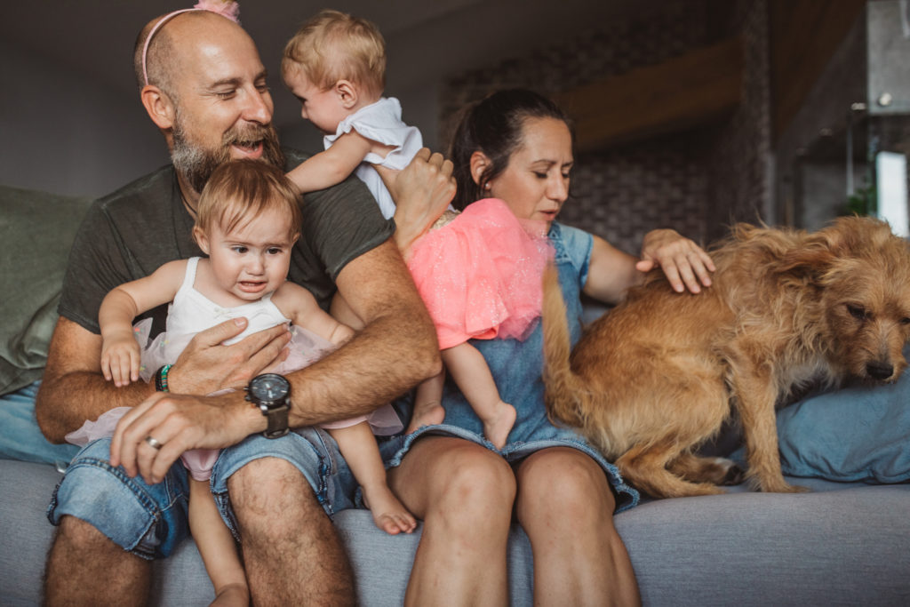 Father and mother trying to make a family photo, but babies are crying.